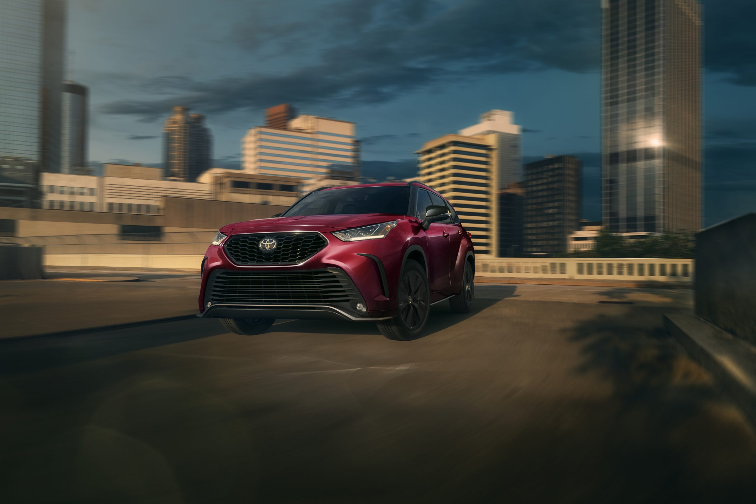 2026 Toyota Highlander in red driving around the city