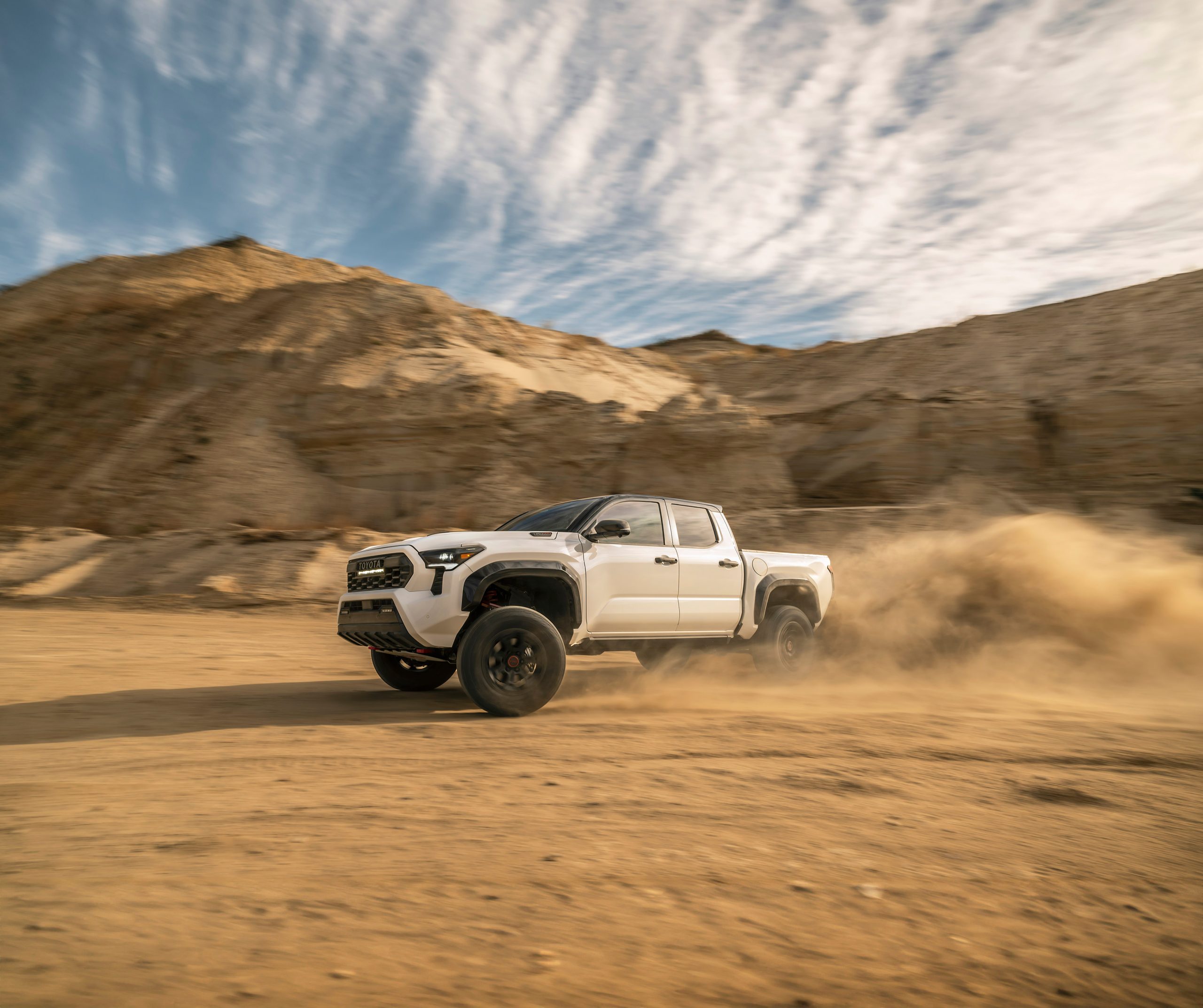 2026 Toyota Tacoma Hybrid White on a dirt road