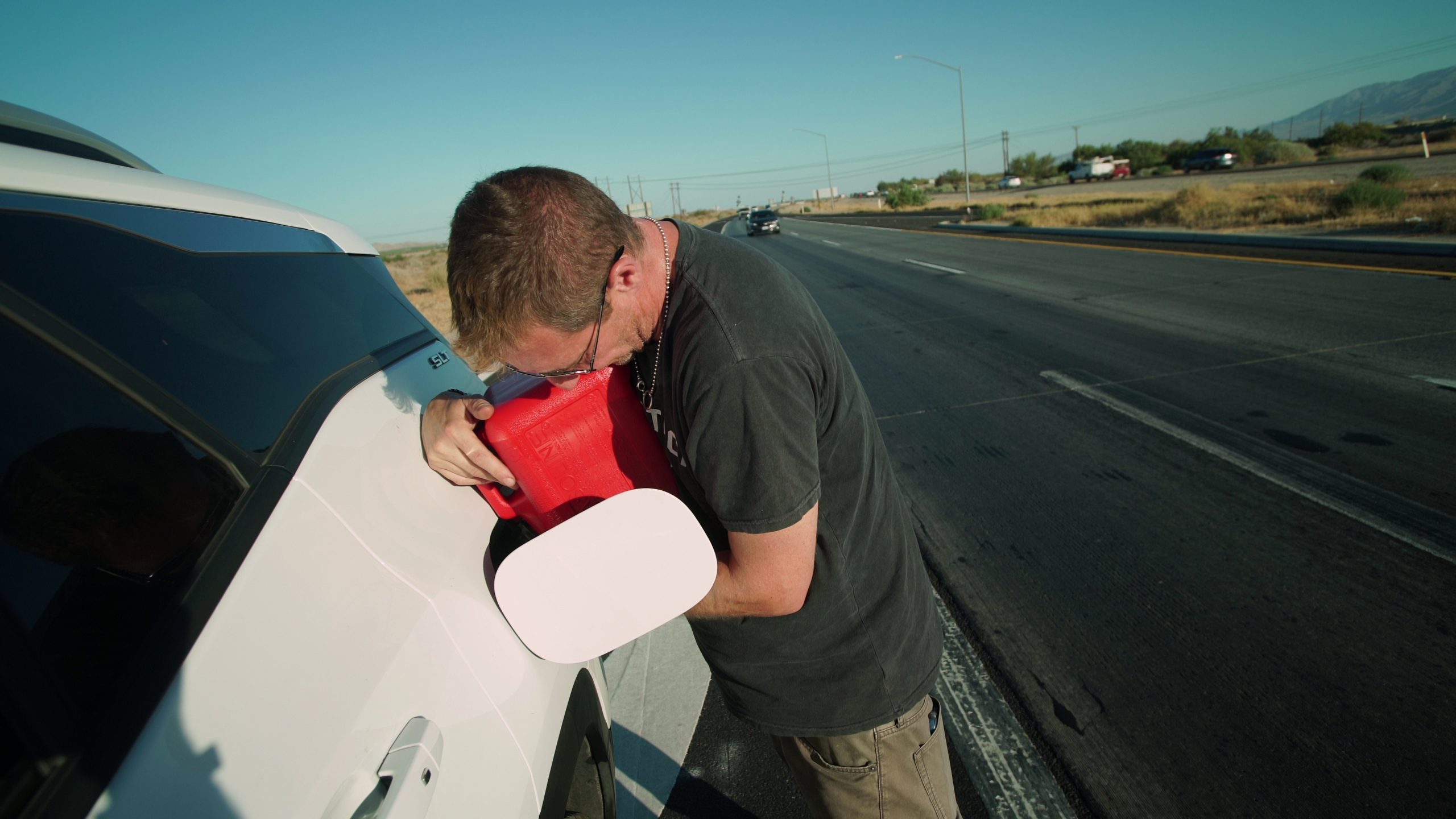 Man filling up gas on the side of the road